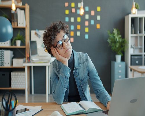 Person resting eyes from laptop screen in a home office